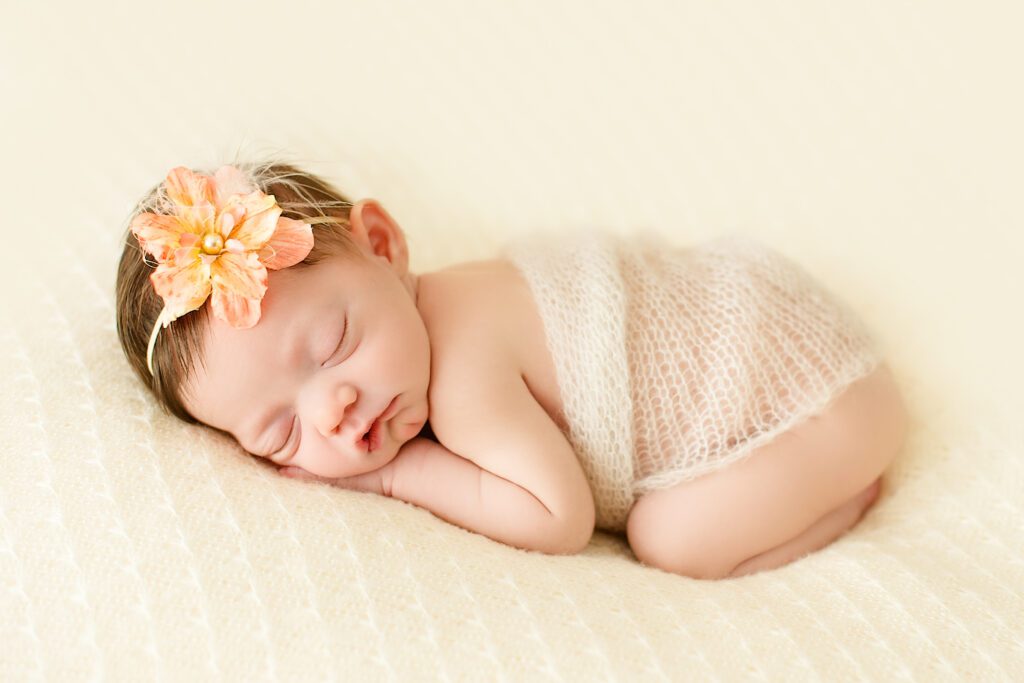 Newborn baby being posed on blanket in order to be photographed.
