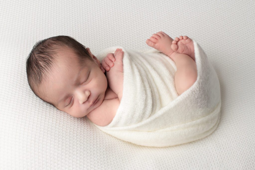 Sleepy newborn on white backdrop. Newborn Photography in Roanoke and Daleville Virginia.